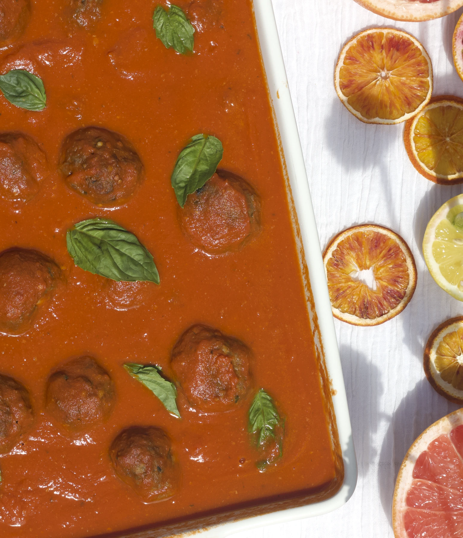 Meatballs in tomato sauce with basil and citrus.